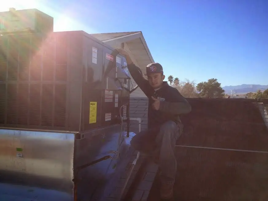 HVAC technician performing Heat Pump Repair on a rooftop unit in Freehold
